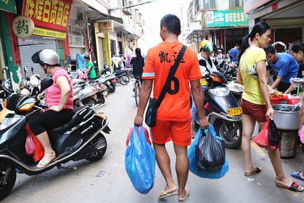 队员提着一袋袋的菜