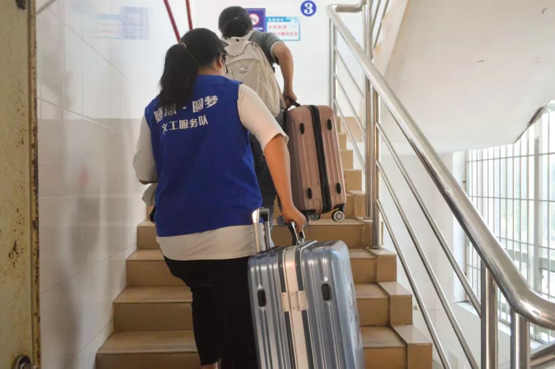 党员志愿者帮助新生提行李.jpg 党员志愿者帮助新生提行李.jpg